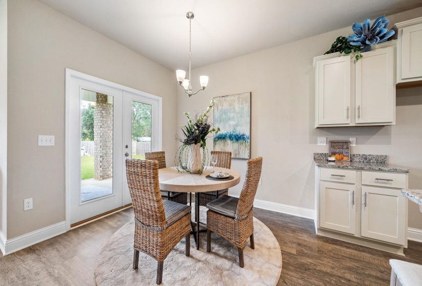 Dining area with dark wood-type flooring and an inviting chandelier