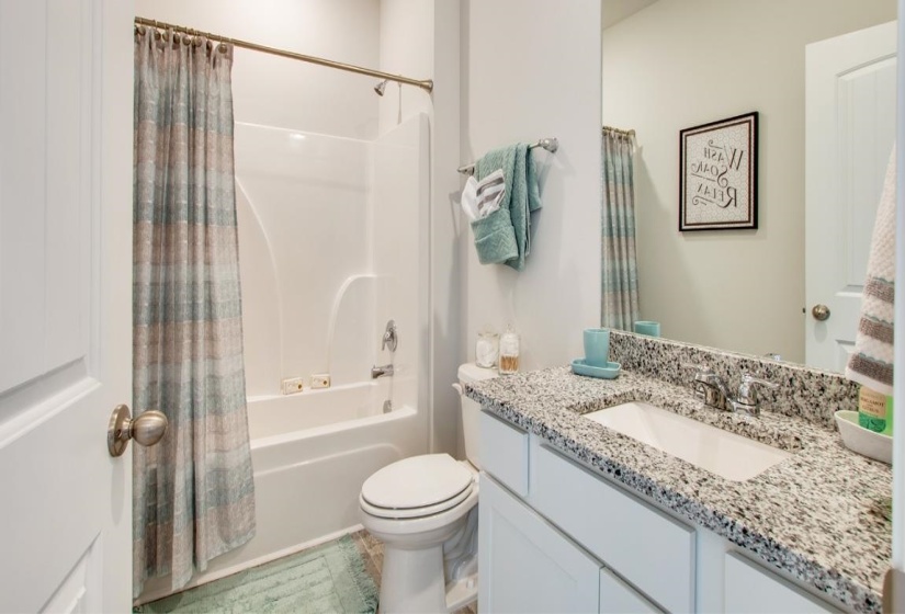 Full bathroom featuring vanity, shower / bath combo with shower curtain, and toilet