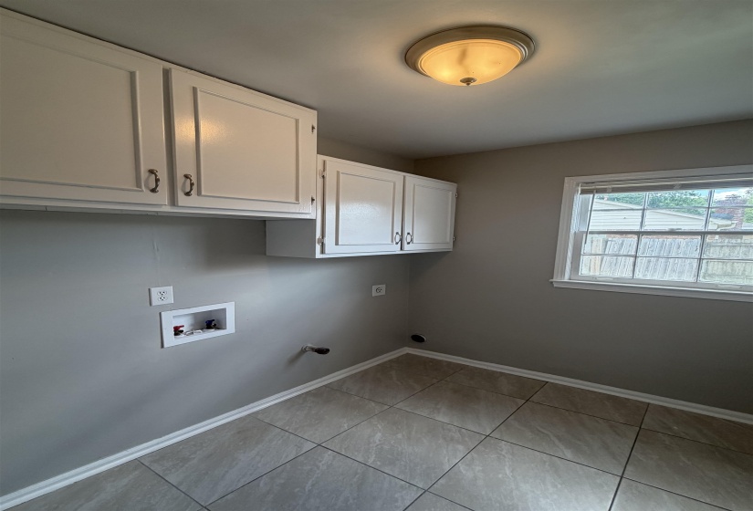 Laundry room featuring tiled flooring, a window, white cabinetry, a flush-mount ceiling light, and wall connections for appliances
