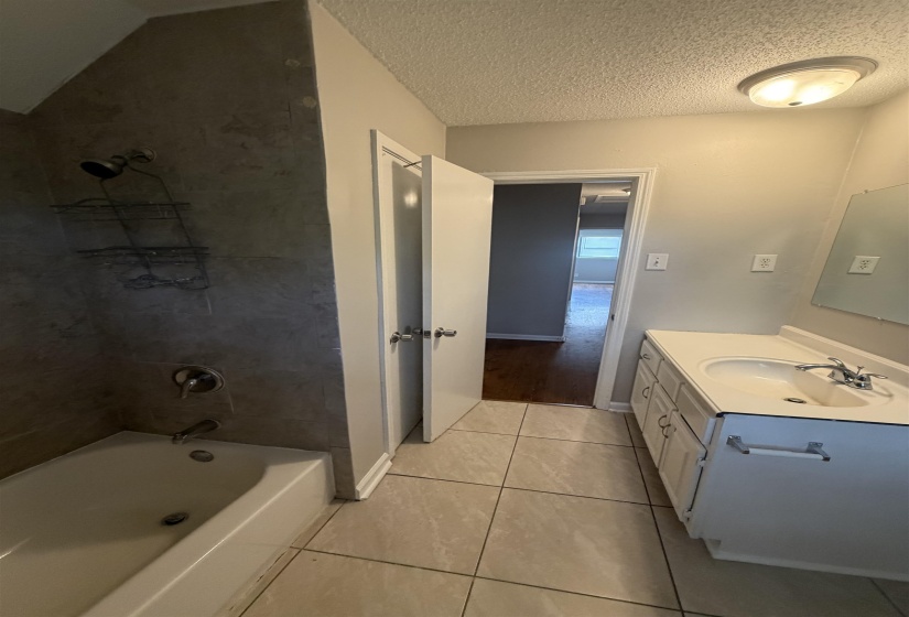 Bathroom featuring a single vanity with storage, tile flooring, a tub-shower combination, and a flush-mount ceiling light