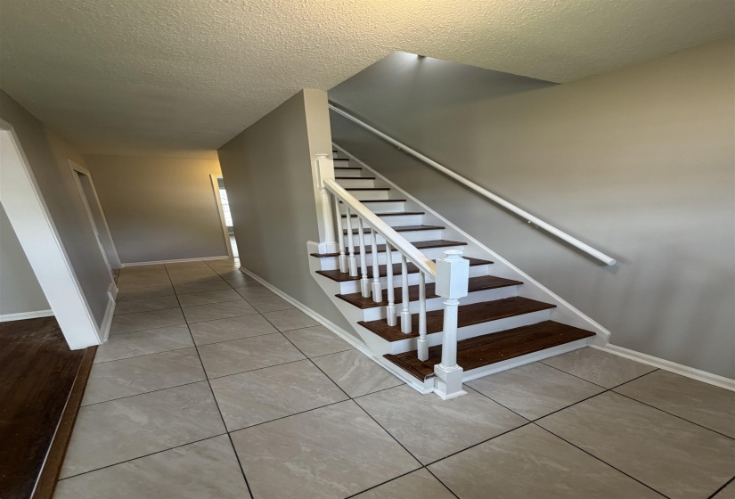 Split-level staircase featuring dark wood-finish treads and white risers with a matching railing and balusters