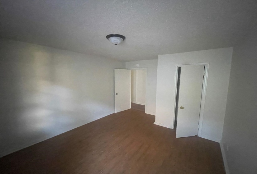 Room featuring wood-finish flooring, white walls, and a ceiling-mounted light fixture