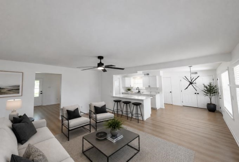 Open-concept living space featuring wood-finish flooring, a contemporary ceiling fan, and recessed lighting