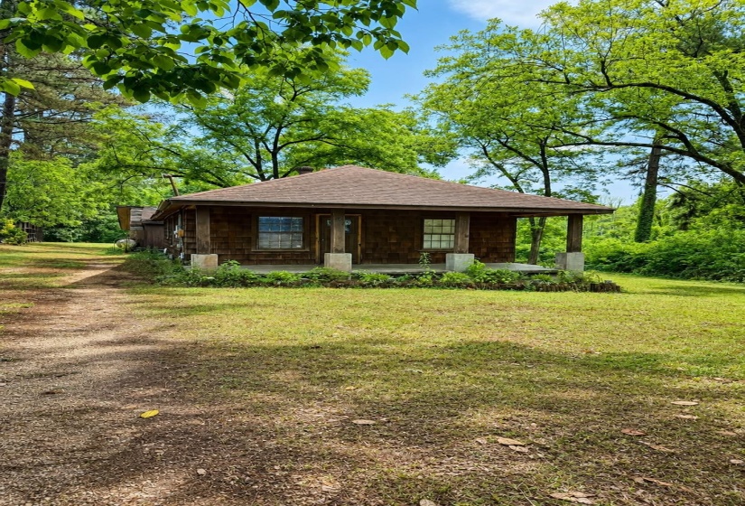 Shingle-sided residence featuring a covered front porch with pillar supports