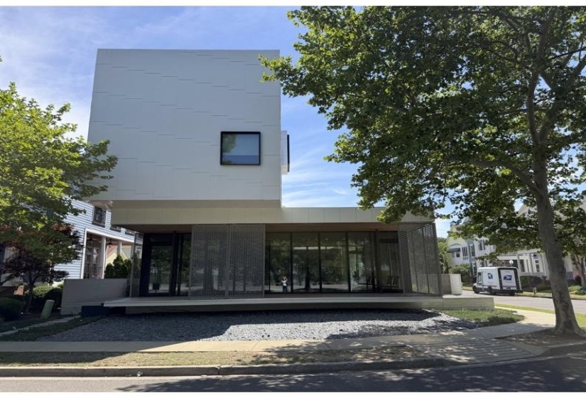 Modern architectural residence featuring a white paneled facade