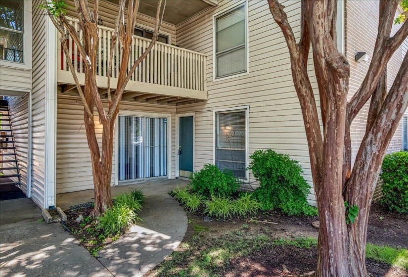 Ground-level entry featuring a teal front door and sliding glass patio doors