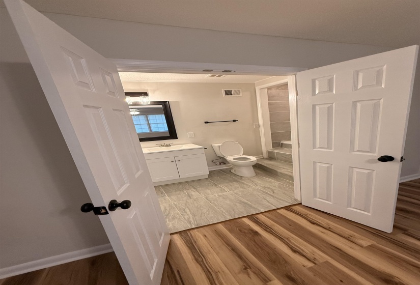 White vanity with integrated sink, black framed mirror, and chrome-finish lighting fixture