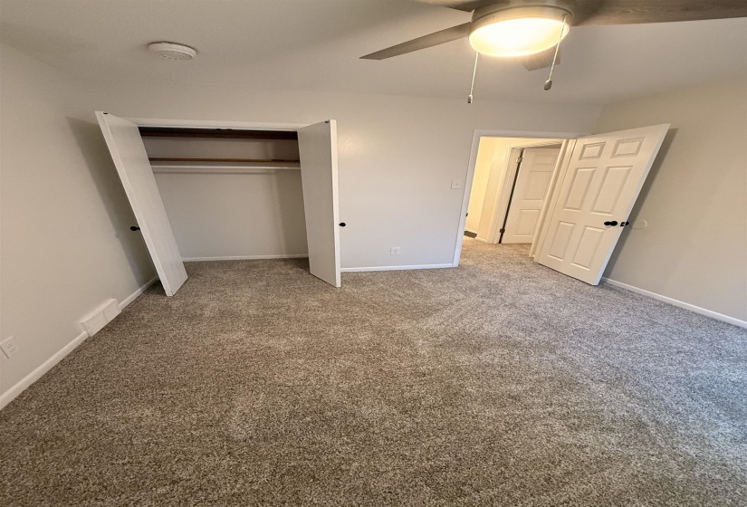 Room featuring plush carpeting, a ceiling fan with integrated lighting, and a closet with bifold doors