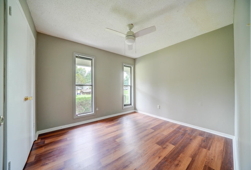 Spare room with a textured ceiling, wood finished floors, and a ceiling fan