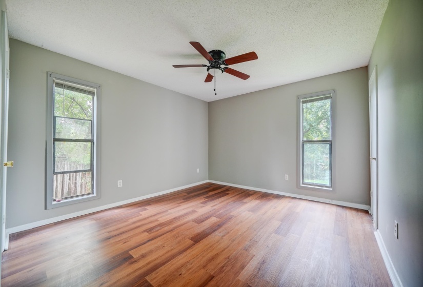 Unfurnished room featuring light wood-style floors, a textured ceiling, and a ceiling fan