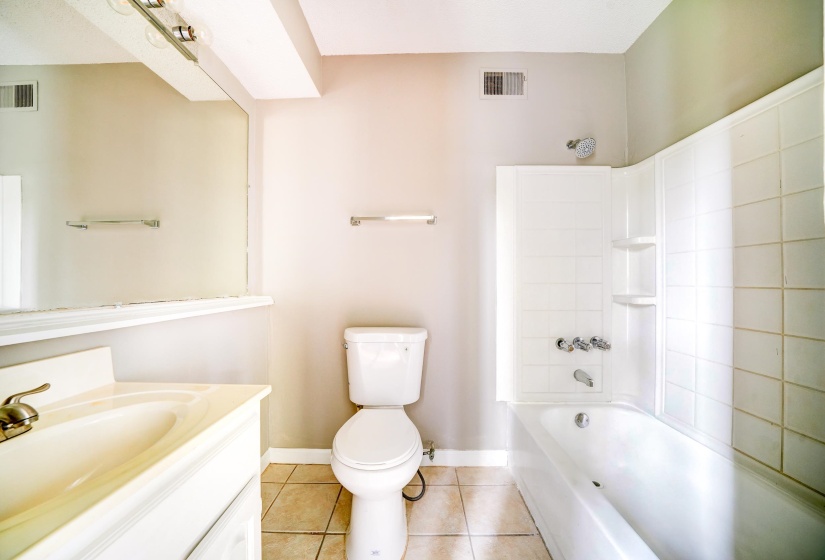 Full bathroom with light tile patterned floors, shower / washtub combination, and vanity