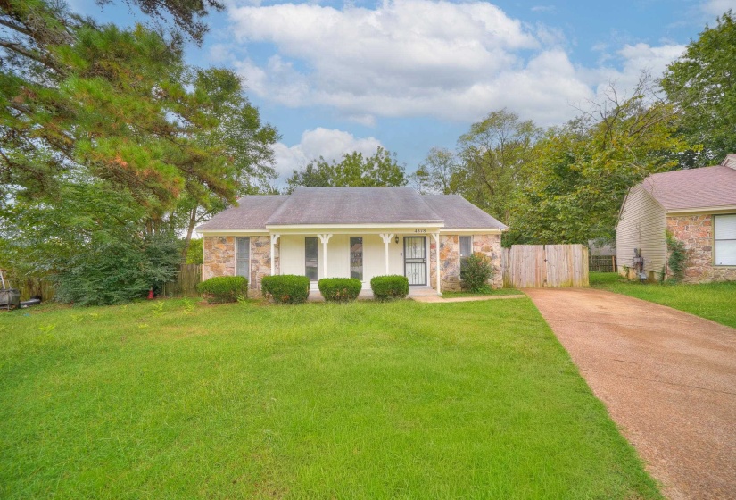 Single story home with a porch, stone siding, and driveway