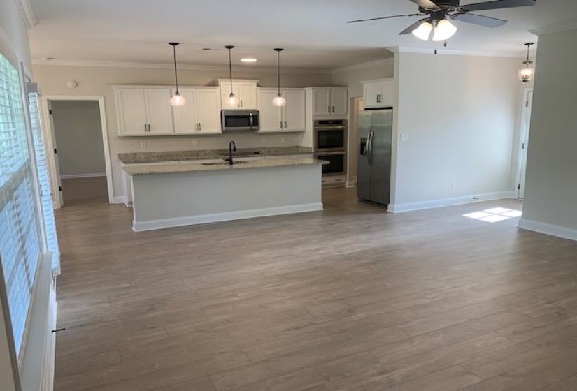 Kitchen with ceiling fan, baseboards, ornamental molding, and stainless steel appliances