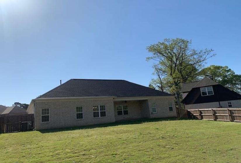 Back of house featuring a fenced backyard and a lawn