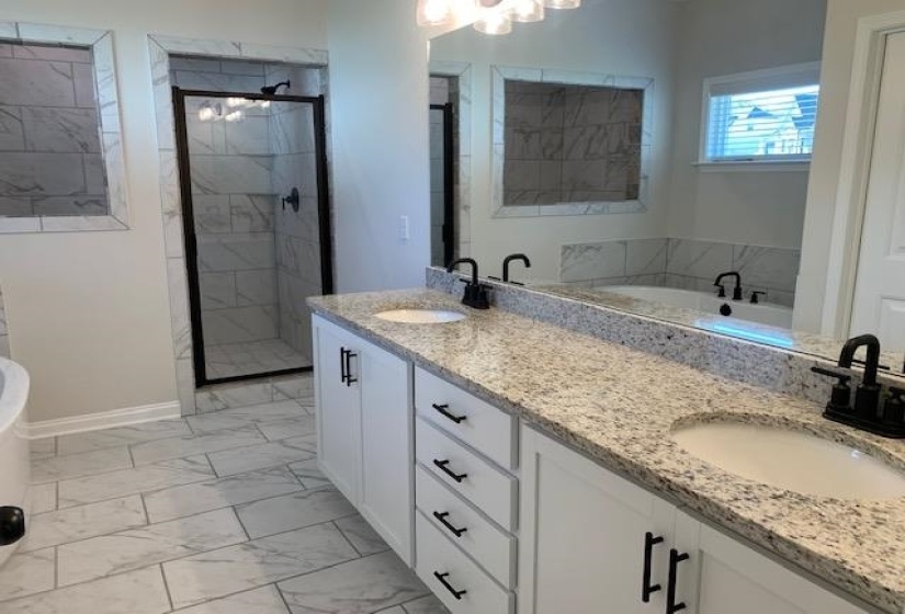 Full bathroom featuring a tub, marble finish floor, a sink, and a tile shower