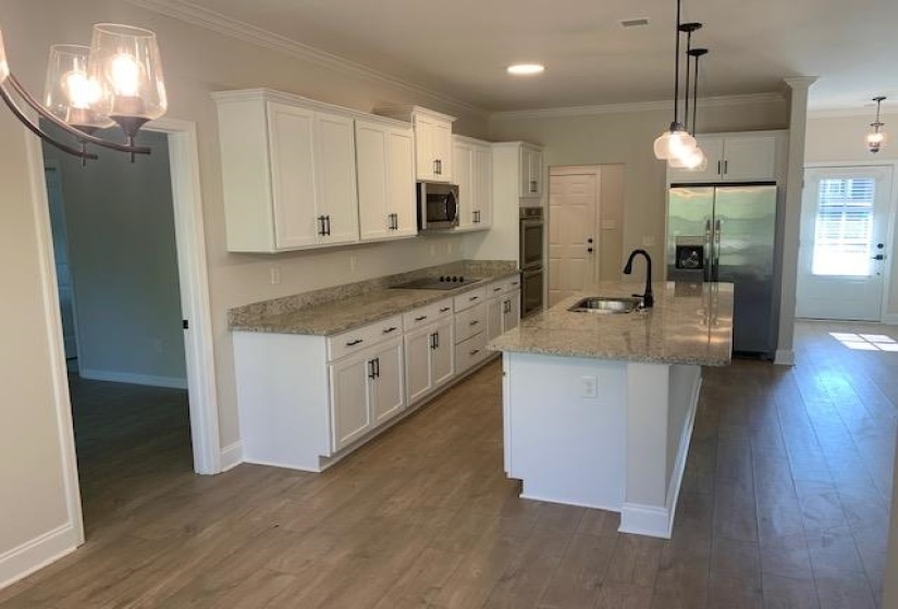 Kitchen featuring a sink, dark wood-style flooring, crown molding, and stainless steel appliances