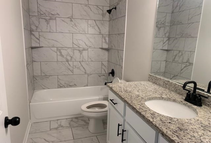 Bathroom with vanity,  shower combination, toilet, marble finish floor, and baseboards
