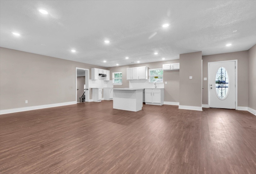 Open-concept living space featuring wood-finish flooring, recessed lighting, and a neutral wall palette