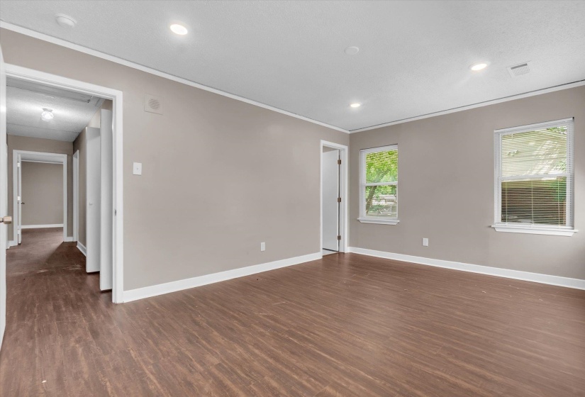 Spacious room featuring wood-finish flooring, light neutral wall paint, and white trim