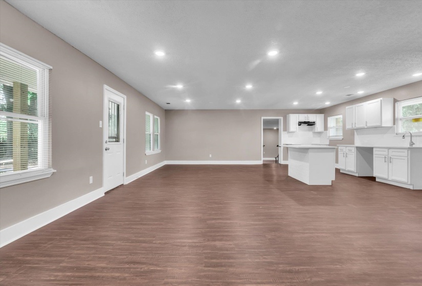 Expansive living space featuring wood-finish flooring, recessed lighting, and neutral wall tones