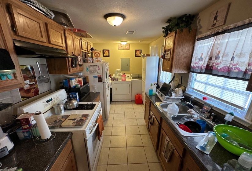 Galley kitchen featuring wood cabinetry and tile flooring