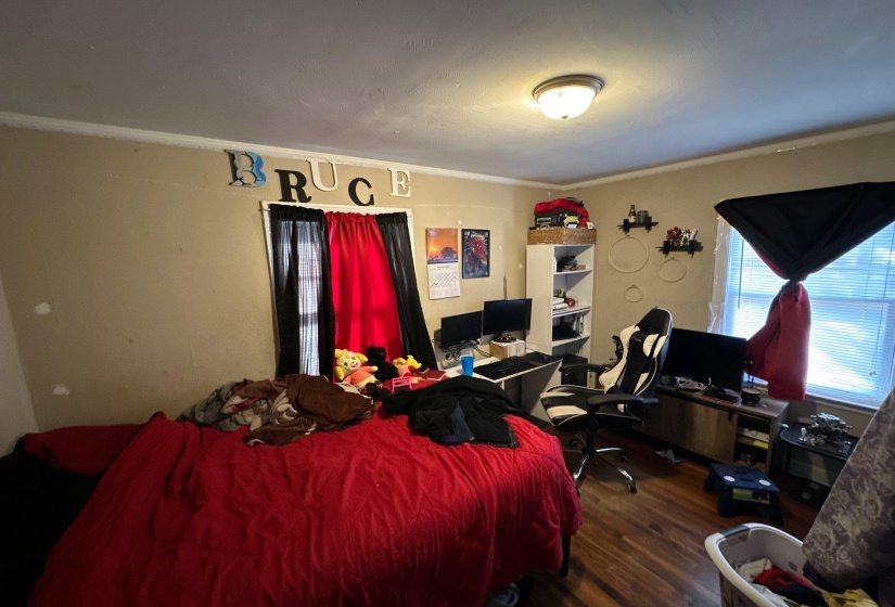 Interior room featuring wood-finish flooring, a flush-mount ceiling light fixture, and neutral wall tones