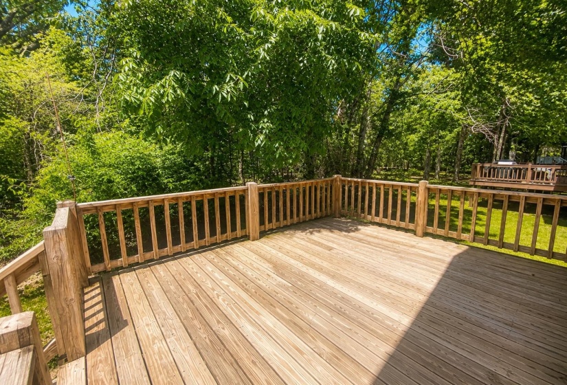 Spacious outdoor deck featuring natural wood decking and matching railings