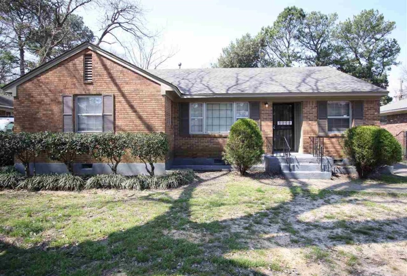Brick facade ranch-style residence featuring a prominent gable, window shutters, and a covered entry