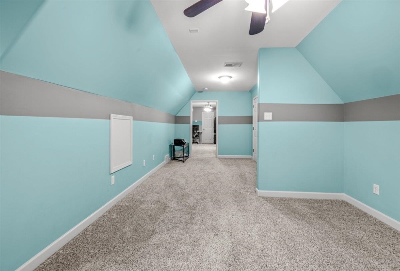 Carpeted room featuring sloped ceilings with recessed lighting, a ceiling fan, light blue and gray painted walls, and white trim