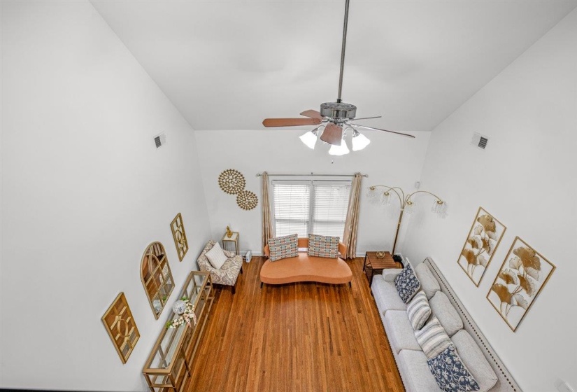 Spacious living area featuring high vaulted ceilings and wood-finish flooring