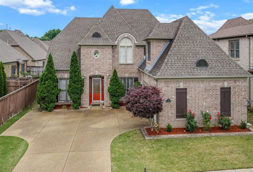 Brick exterior residence featuring a gabled roofline and an arched dormer window