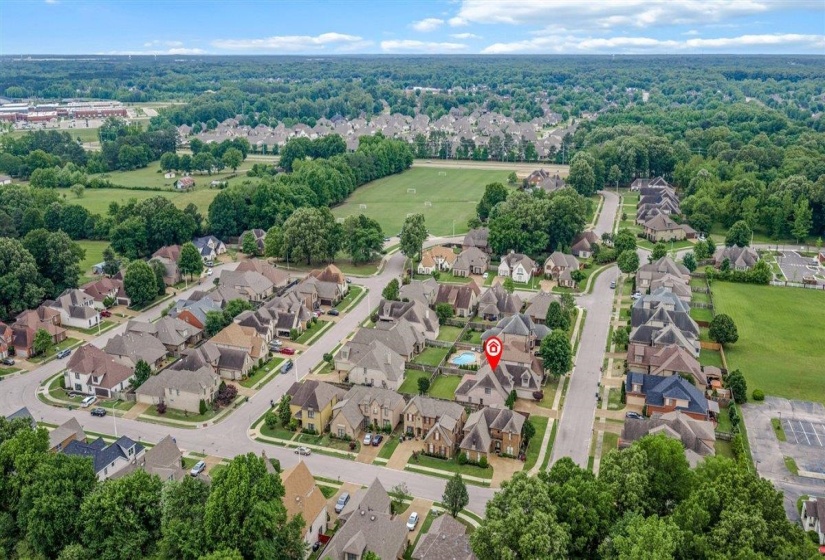 Aerial perspective showcasing a residential neighborhood with tree-lined streets and varied architectural home styles