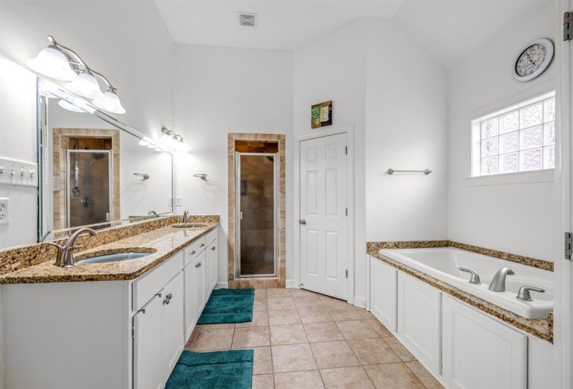 Bathroom featuring a double vanity with granite countertops, dual vessel sinks, and brushed nickel fixtures