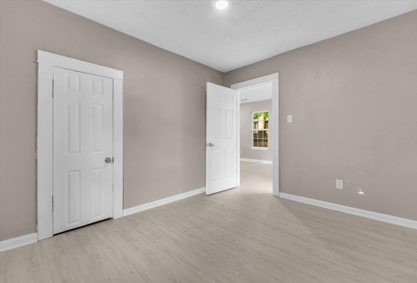 Neutral-toned room featuring light wood-finish flooring, recessed lighting, and white trim