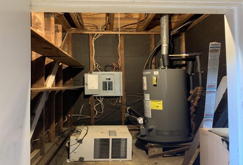 Utility area featuring a water heater, electrical panel, and exposed wood framing