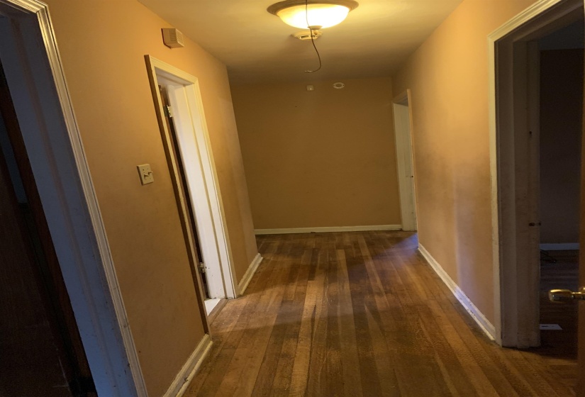 Hallway featuring wood-finish flooring and multiple doorways