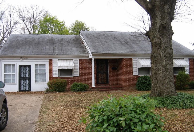 Brick and white facade home featuring a gabled roofline and front porch entry