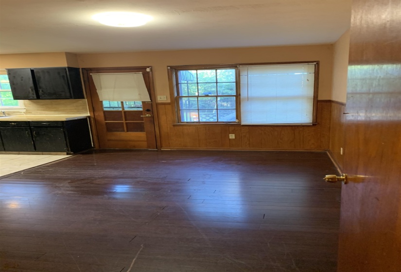 Dark wood-finish flooring with light-toned walls and wood paneling