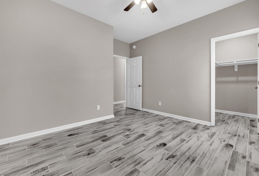 Neutral tone walls with white trim, complemented by wood-finish plank flooring