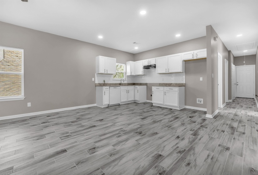 Open-concept living space featuring wood-finish tile flooring and recessed lighting