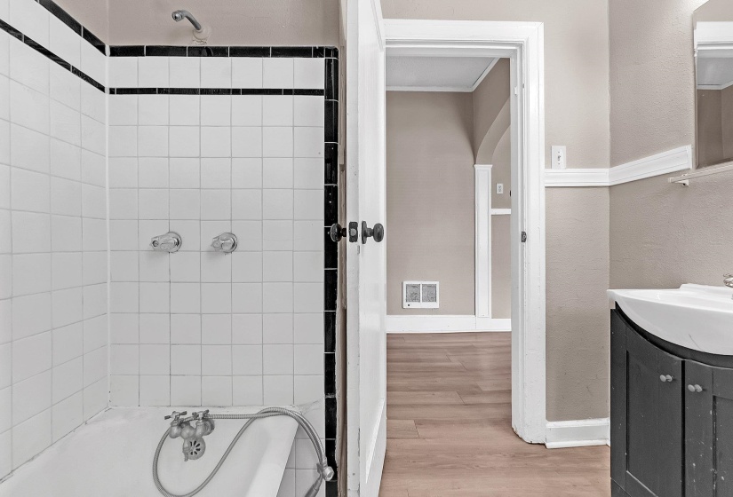 White subway tile shower surround with black accent trim and chrome fixtures