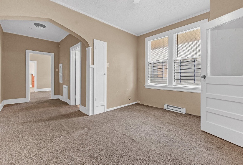 Carpeted interior space with a light beige wall color, white trim, and a white interior door