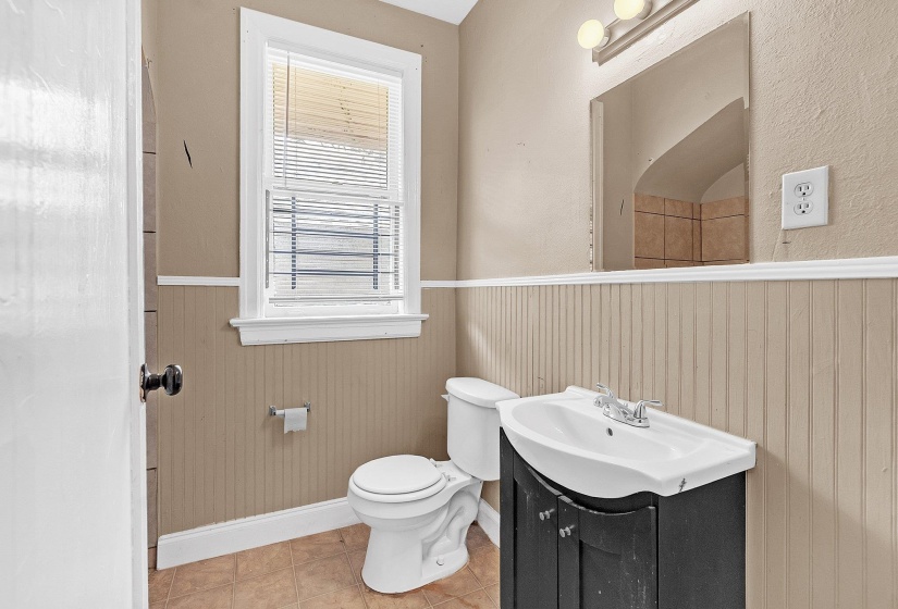 Bathroom featuring a vanity with an integrated sink, mirror, and two-light fixture