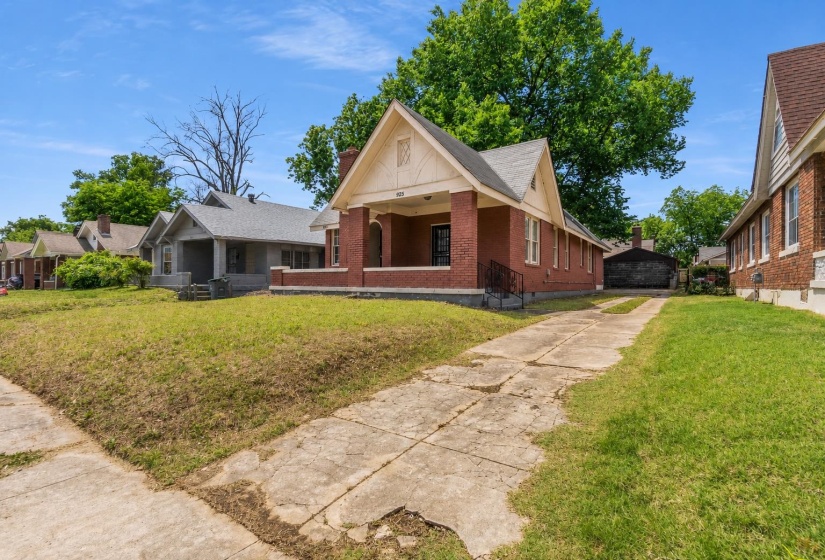 Brick exterior residential property with a covered front porch featuring columns and a gable roof with decorative trim