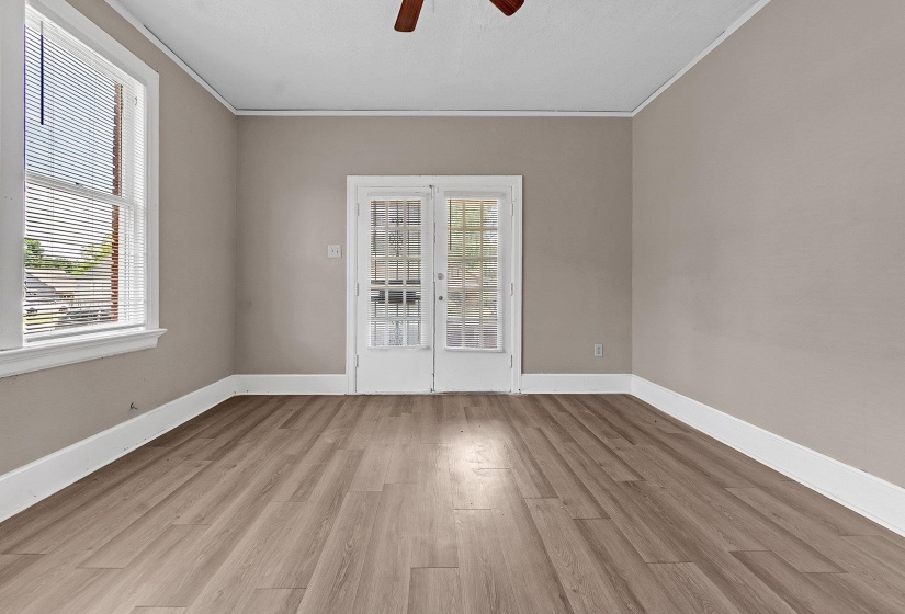 Room featuring wood-finish flooring, neutral wall tones, white baseboards, and white window trim