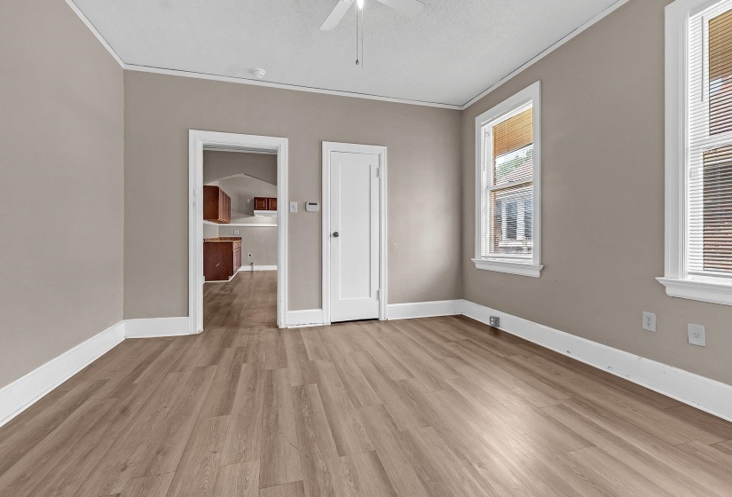 Room with wood-finish flooring, neutral wall paint, and white trim