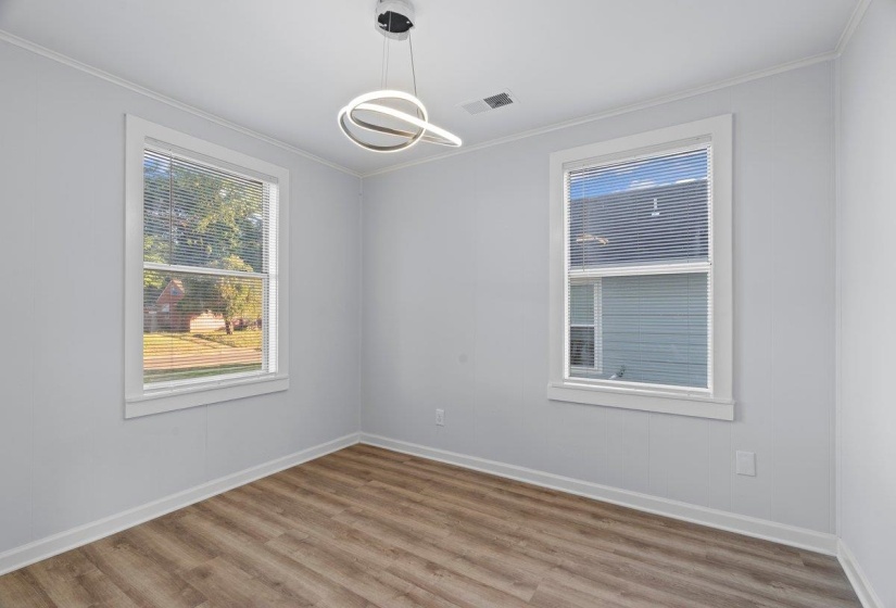 Light-filled room featuring wood-finish flooring and a modern ceiling light fixture