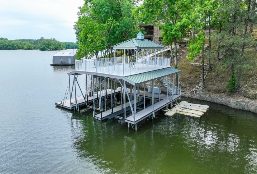 Two-story boat dock featuring multiple boat slips, an upper-level deck, and a top-level gazebo