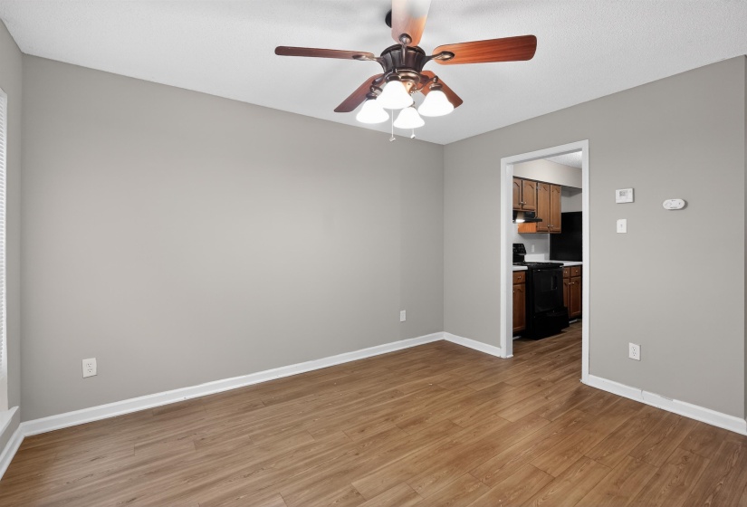 Wood-finish flooring throughout, complemented by light grey wall paint and white baseboards