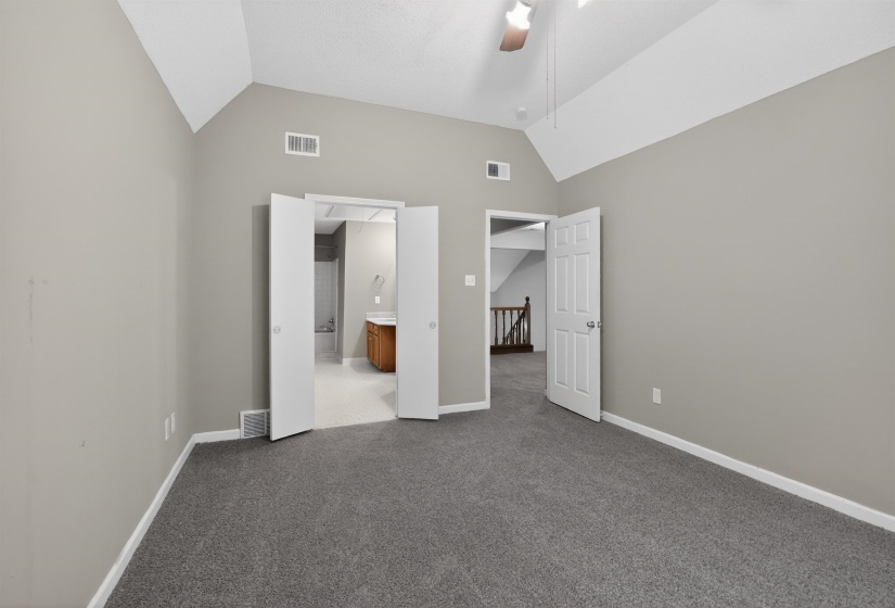Carpeted interior space with vaulted ceilings and a ceiling fan